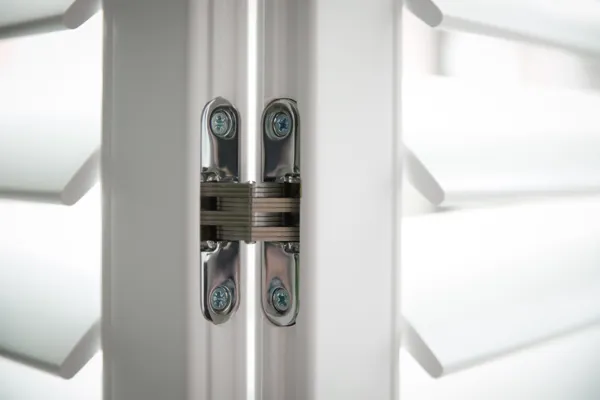 close up of shutter hinge connecting two white shutters
