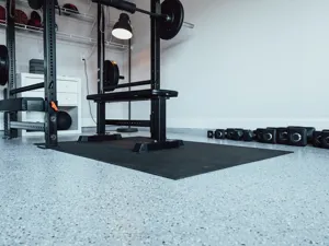 A home gym with bench pressc, barbells and weights.