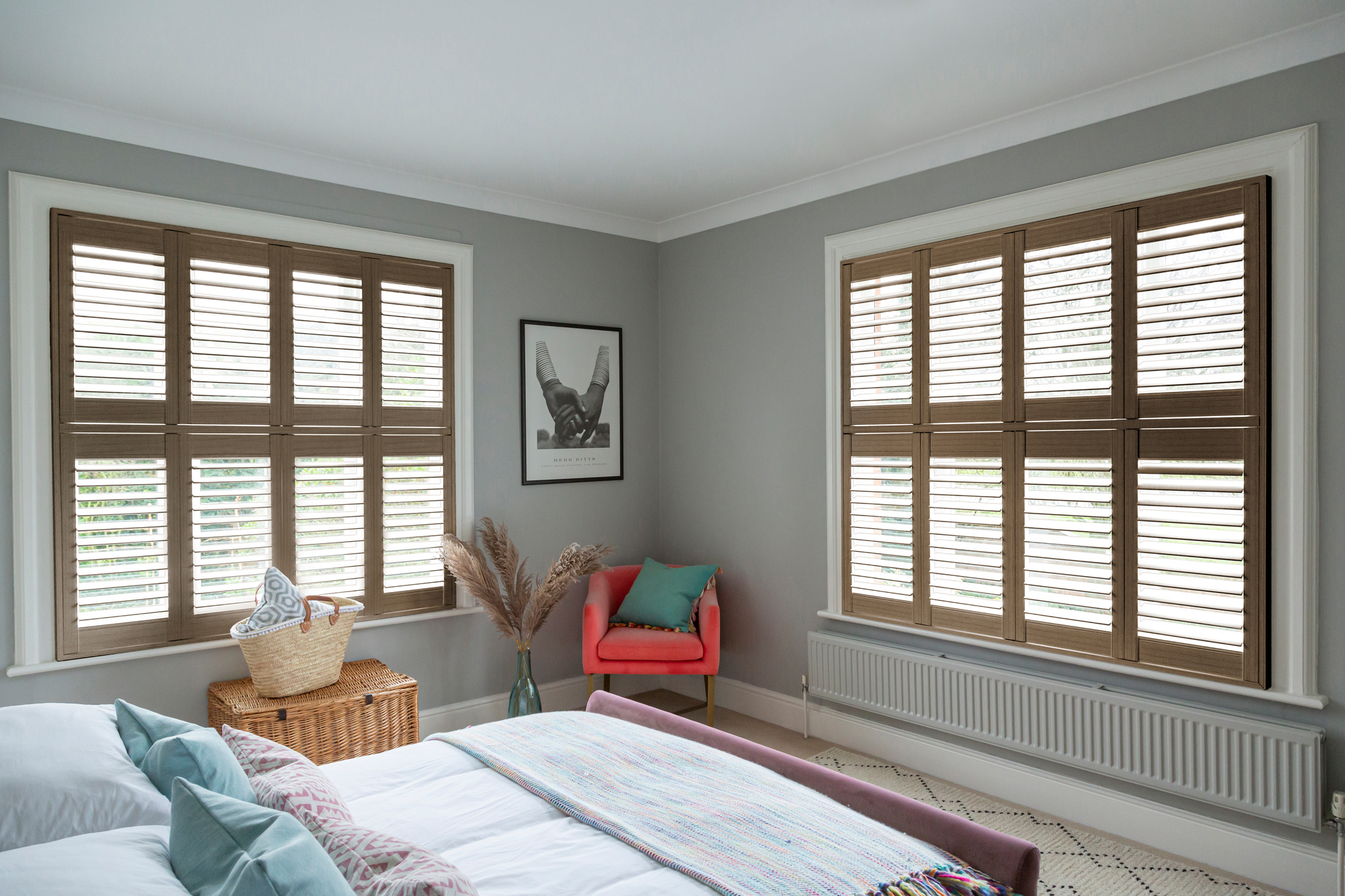 Vintage oak dark brown shutters fitted to two windows in a grey decorated bedroom