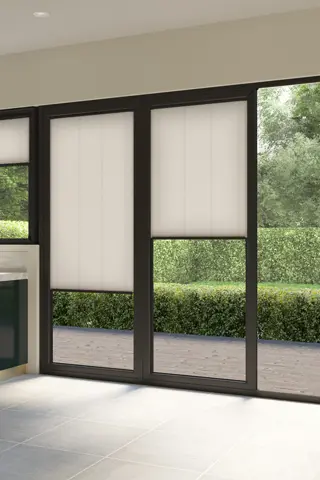 White coloured blinds fitted to bi fold doors in a kitchen with white flooring, navy kitchen cabinets and white dining table