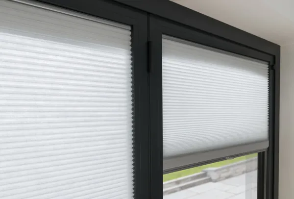 white coloured pleated blinds fitted inside the recess of a black framed window