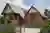 Large house with attached garage and second storey block with two grey sectional garage doors.