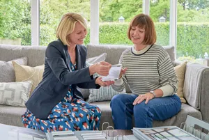 two women at table looking at fabric and hardware samples