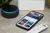 Smart hub, Amazon Echo Dot, mobile phone and remote control sitting on a marble counter.