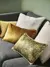 Close up of dark grey sofa with cushions in beige, gold, copper and ochre.