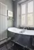 white shutters in bathroom with vertical radiator and a bath with a navy blue outside