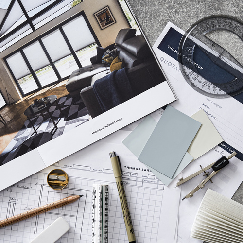 A range of brochures and technical paperwork, pencils, ruler, protractor, pair of compass and three pastel blue and cream colour swatches.