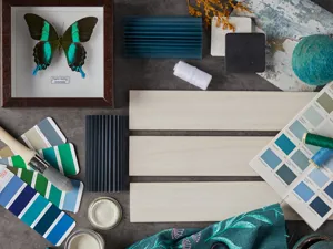 Moodboard in green, teal and blue tones with paint samples, fabric samples and shutter samples in cream.