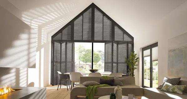 black tier on tier shutters fitted to a gable end window in an open plan living room and dining room