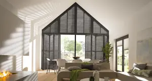 black tier on tier shutters fitted to a gable end window in an open plan living room and dining room