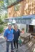 Matt and Lisa Tebbutt stood on their patio with their awning, a table and benches are positioned under the awning