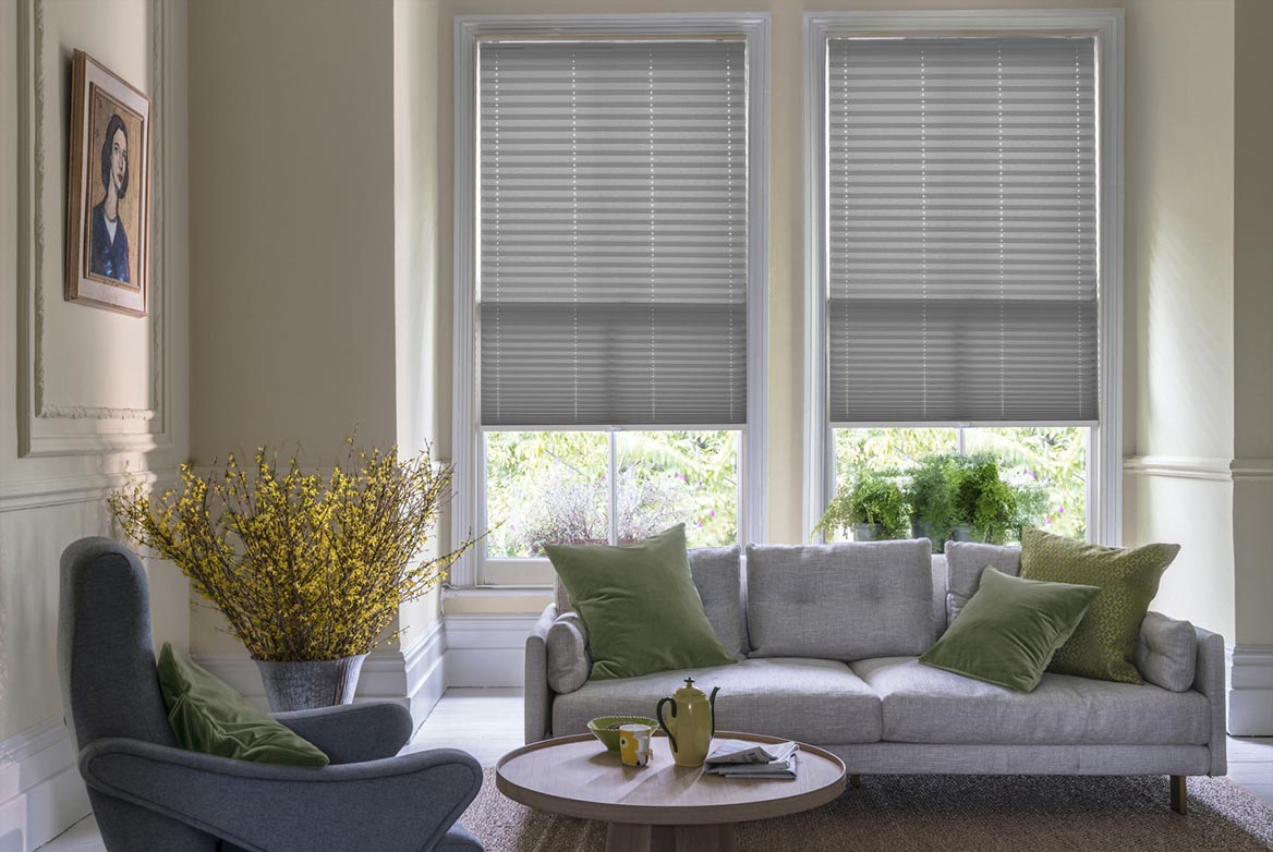 Fitted to multiple windows in a marble and white decorated kitchen are Solartex Chintz Pewter Pleated blind. The plain design of these grey Pleated blinds completes the look.