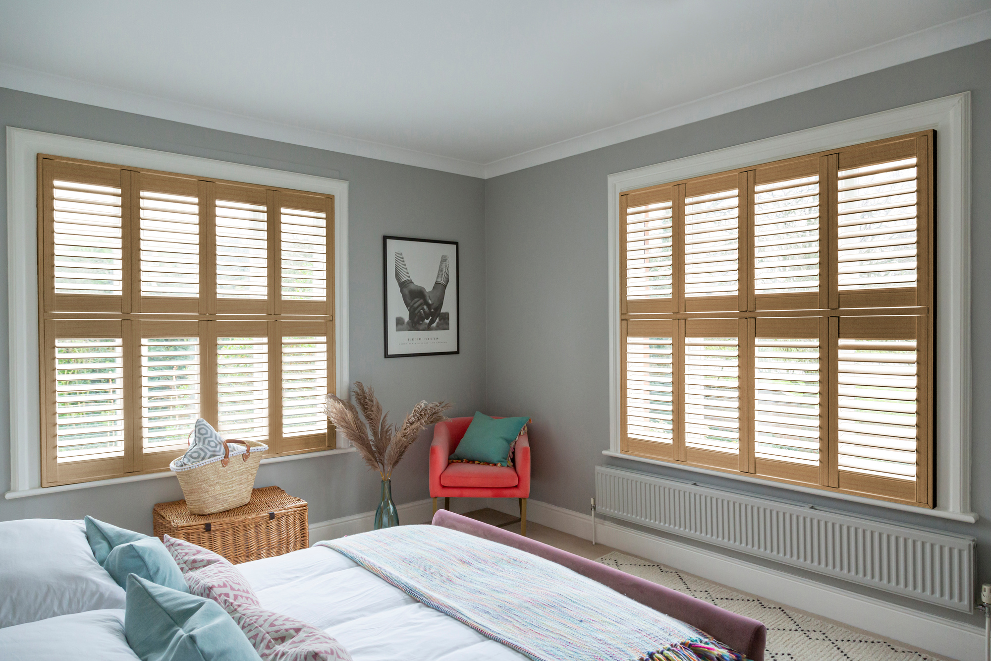 Chestnut light brown shutters fitted to two windows in a grey decorated bedroom