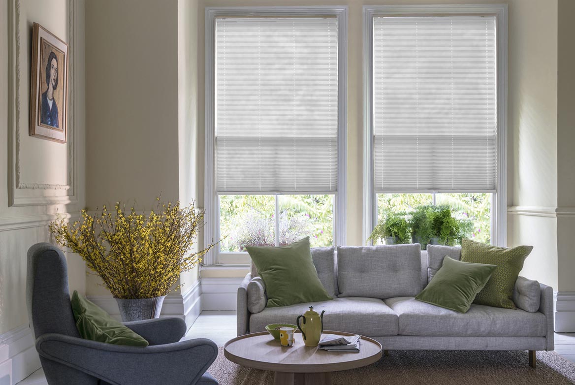 Fitted to multiple windows in a marble and white decorated kitchen are Lumina Sheer White Pleated blind. The plain design of these white Pleated blinds completes the look.