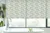 Bathroom with flagstone tile floor, pale green walls and ceiling white bath in front of picture windows dressed in roller blind with fern pattern.