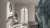 White bathroom with large arch window dressed in white shutters, closed with louvres open, abstract blue feature wall on right beside bath.