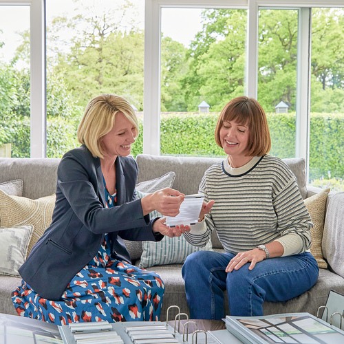 two women at table looking at fabric and hardware samples