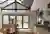 Kitchen with wooden island in front of a gable end window dressed in ochre blinds at varying levels.