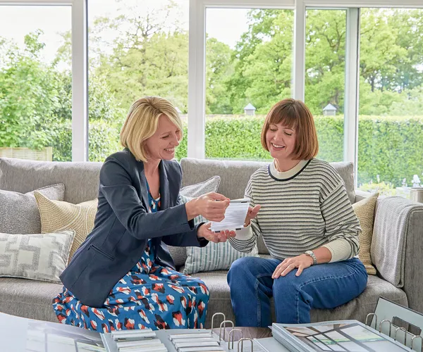 two women at table looking at fabric and hardware samples