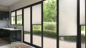 White Duette blinds fiited to bi fold doors in a kitchen with wooden floors, dark kitchen cabinets and marble counters