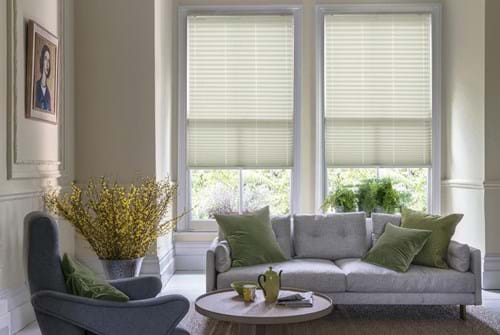 Fitted to multiple windows in a marble and white decorated kitchen are Aspect Sand Castle Pleated blind. The stripe design of these natural Pleated blinds completes the look.