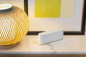 White marble unit top with round lamp, Mondrian-style yellow picture in black frame and a white smart hub.