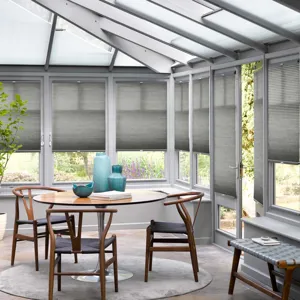 mid grey pleated conservatory blinds in conservatory with circular wooden table and chairs