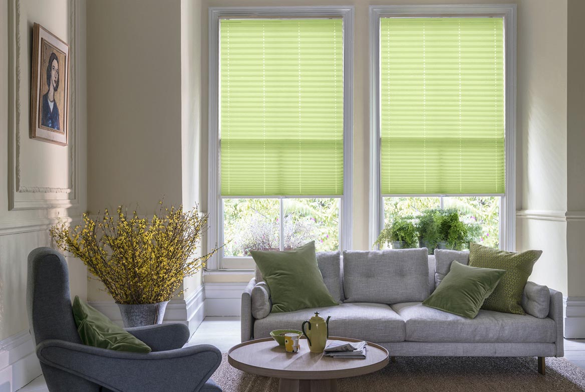 Fitted to multiple windows in a marble and white decorated kitchen are California Leaf Pleated blind. The plain design of these green Pleated blinds completes the look.